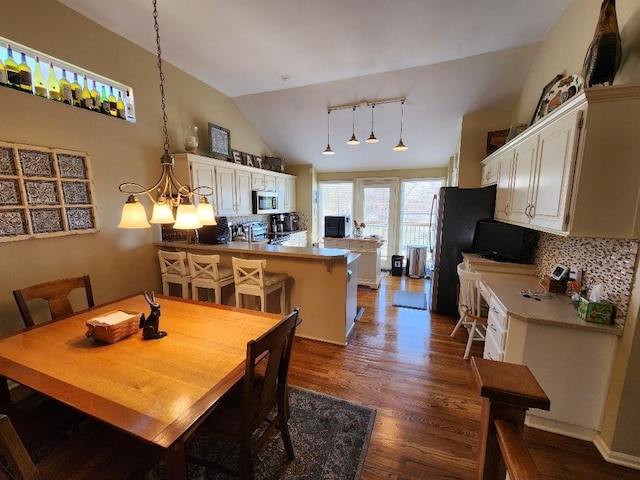 5773 Meadow Heights Dr, Shawnee, KS 66226 - dining area with dark wood-style floors, lofted ceiling, a chandelier, and track lighting