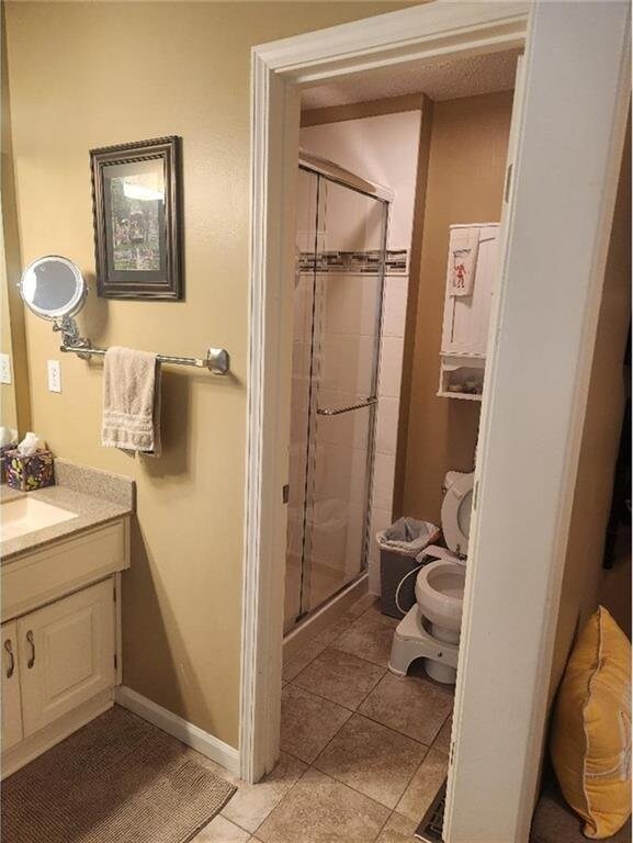 5773 Meadow Heights Dr, Shawnee, KS 66226 - full bathroom with a stall shower, vanity, tile patterned floors, and baseboards