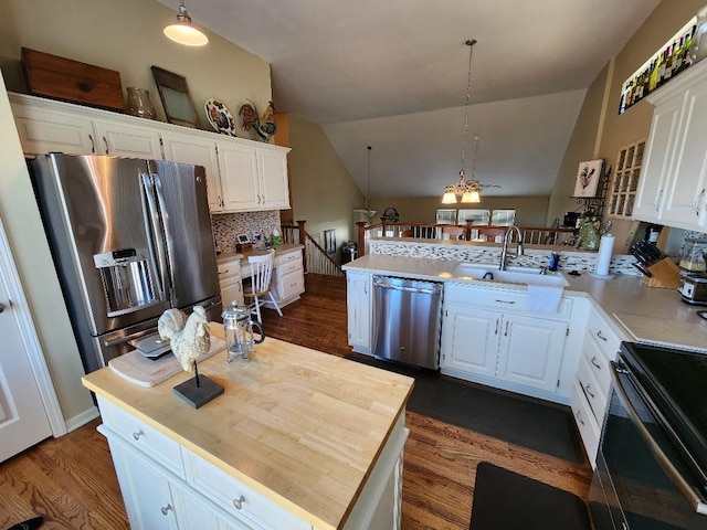 5773 Meadow Heights Dr, Shawnee, KS 66226 - kitchen featuring appliances with stainless steel finishes, a sink, a peninsula, white cabinets, and dark wood-type flooring