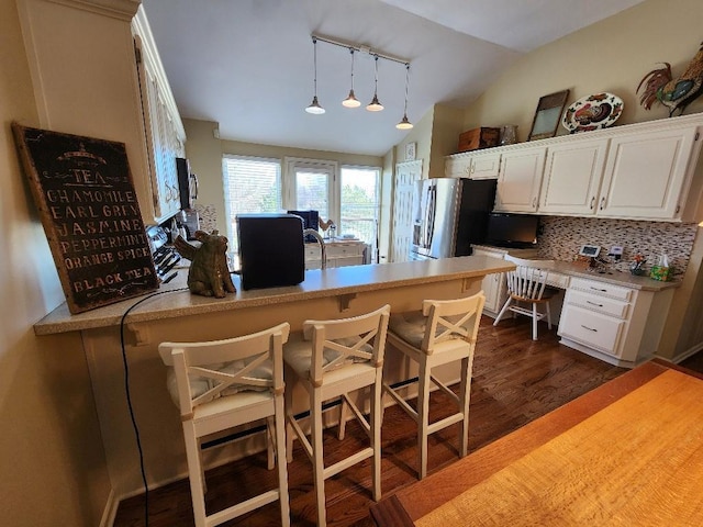5773 Meadow Heights Dr, Shawnee, KS 66226 - kitchen featuring rail lighting, lofted ceiling, white cabinets, stainless steel fridge, and dark wood finished floors