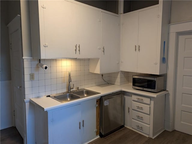 kitchen with light countertops, appliances with stainless steel finishes, decorative backsplash, and a sink