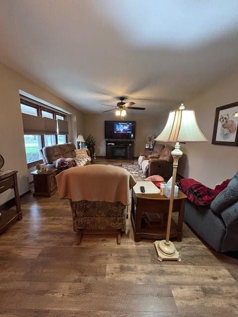 living area with wood finished floors and a ceiling fan