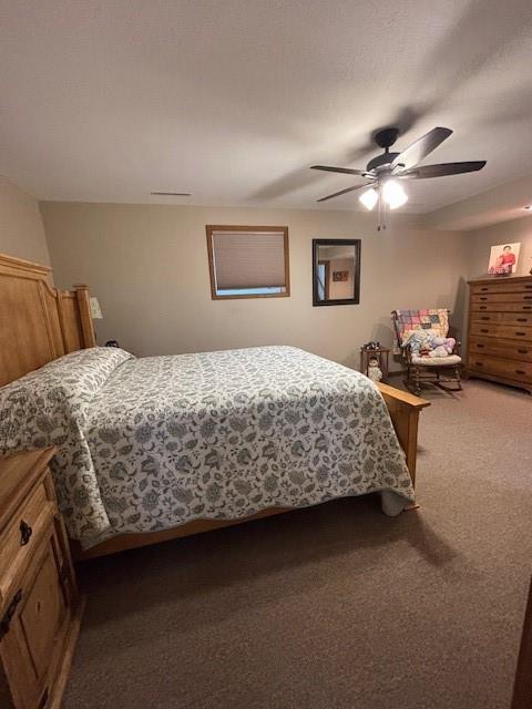 bedroom featuring a ceiling fan and dark carpet
