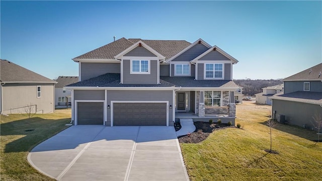 11410 S Langley St, Olathe, KS 66061 - craftsman house featuring covered porch, an attached garage, concrete driveway, and a front lawn