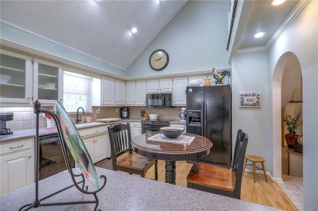 220 NW Aspen St, Lees Summit, MO 64064 - kitchen with light wood-style floors, tasteful backsplash, ornamental molding, black appliances, and a sink