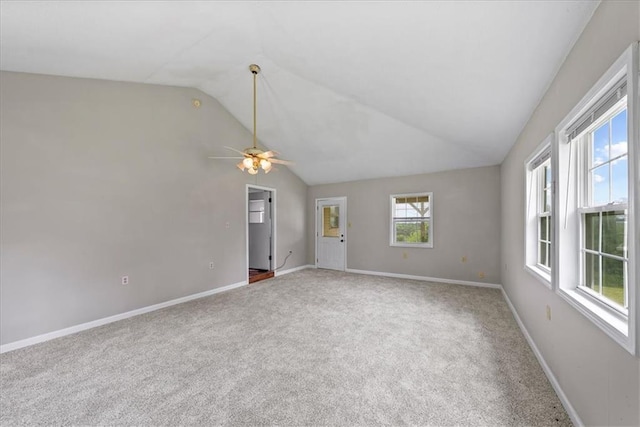 carpeted spare room featuring baseboards, a ceiling fan, and lofted ceiling