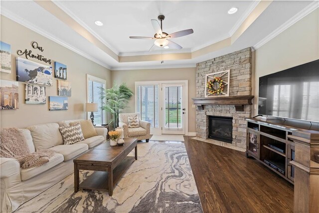11481 S Waterford Dr, Olathe, KS 66061 - living room featuring ornamental molding, wood finished floors, a fireplace, a raised ceiling, and a ceiling fan