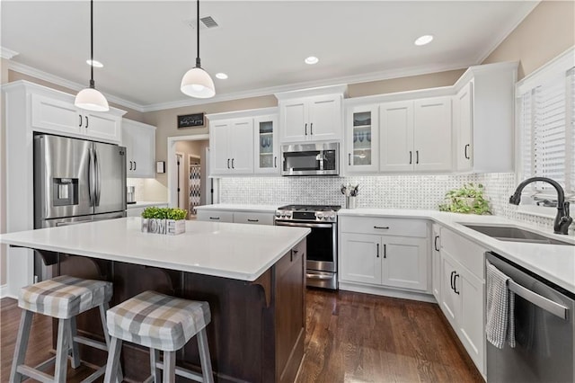 11481 S Waterford Dr, Olathe, KS 66061 - kitchen with appliances with stainless steel finishes, a sink, a kitchen island, visible vents, and glass insert cabinets