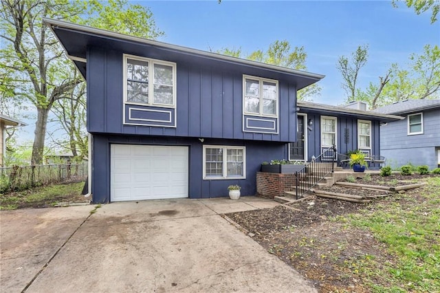 split level home featuring fence, driveway, board and batten siding, and a garage