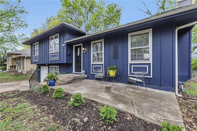 split level home featuring concrete driveway, board and batten siding, and an attached garage