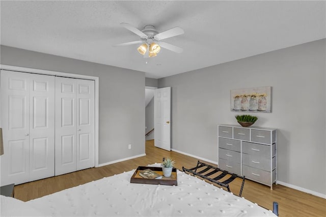 bedroom with baseboards, wood finished floors, and a closet