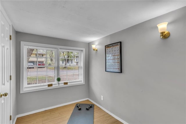 unfurnished dining area featuring wood finished floors and baseboards