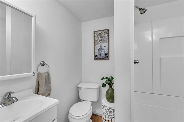 full bath with a shower, wood finished floors, vanity, and toilet