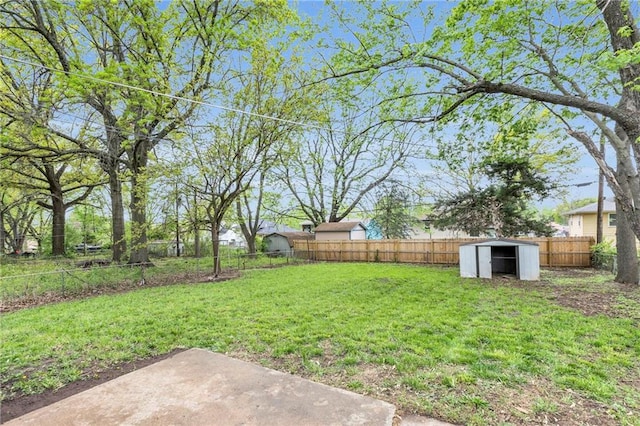 view of yard featuring a storage shed, an outdoor structure, and a fenced backyard