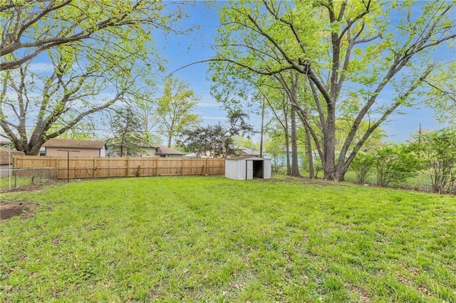 view of yard with a storage shed, an outbuilding, and a fenced backyard