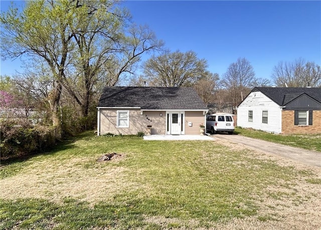 7940 Hickman Mills Dr, Kansas City, MO 64132 - view of front facade with concrete driveway, a front yard, and a patio area