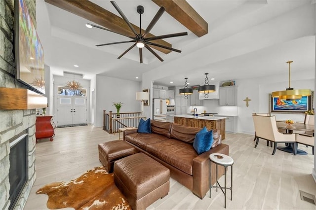 2428 W 179th St, Overland Park, KS 66085 - living room with light wood finished floors, recessed lighting, ceiling fan, a stone fireplace, and baseboards
