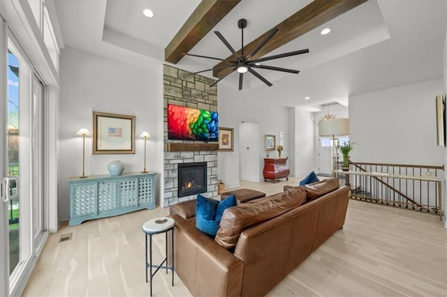 2428 W 179th St, Overland Park, KS 66085 - living room featuring ceiling fan, wood finished floors, plenty of natural light, a stone fireplace, and beam ceiling