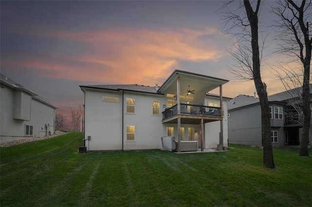 2428 W 179th St, Overland Park, KS 66085 - back of house at dusk with a balcony, ceiling fan, and a yard