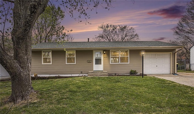 single story home with a lawn, a garage, and concrete driveway