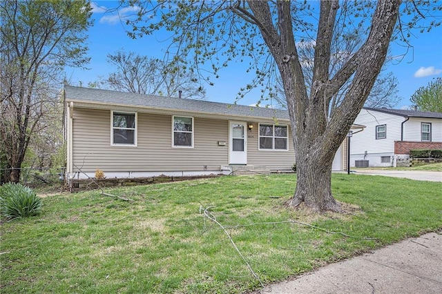 ranch-style house featuring central air condition unit, fence, and a front lawn