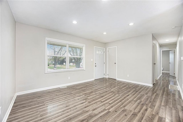 unfurnished living room with baseboards, wood finished floors, and recessed lighting