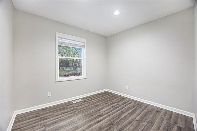 empty room with baseboards, dark wood-style floors, visible vents, and recessed lighting