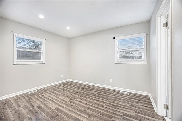 empty room featuring recessed lighting, baseboards, visible vents, and wood finished floors