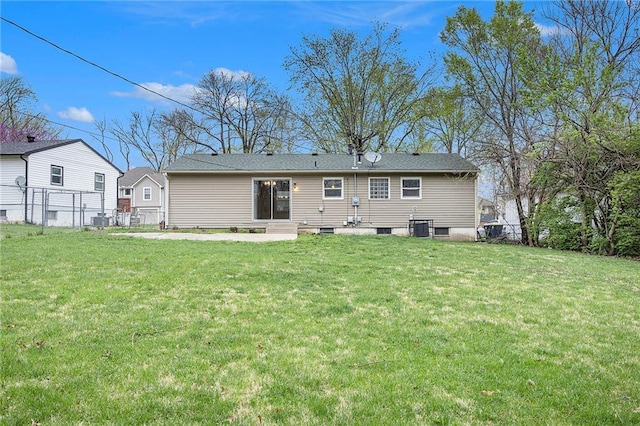 back of property with a lawn, entry steps, and fence