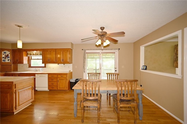2406 NE 78th Ter, Kansas City, MO 64118 - dining space featuring a ceiling fan, healthy amount of natural light, light wood finished floors, and a textured ceiling