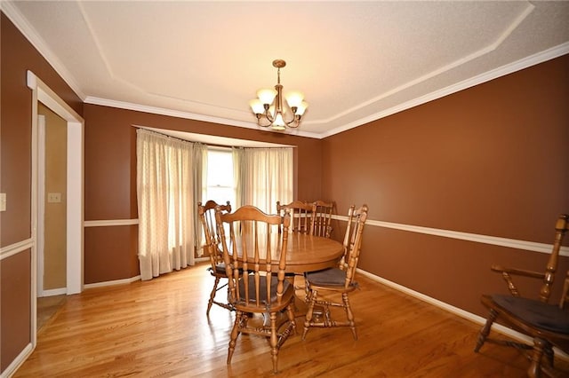 2406 NE 78th Ter, Kansas City, MO 64118 - dining space with a chandelier, light wood-type flooring, baseboards, and crown molding