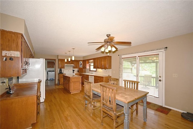 2406 NE 78th Ter, Kansas City, MO 64118 - dining space featuring light wood finished floors, a ceiling fan, baseboards, and a textured ceiling