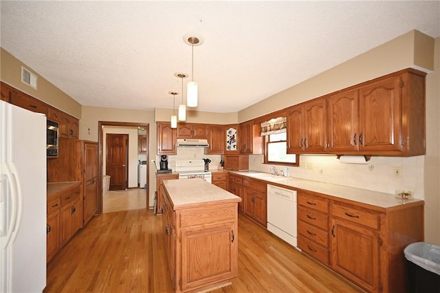 2406 NE 78th Ter, Kansas City, MO 64118 - kitchen featuring white appliances, range hood, light wood-style flooring, and brown cabinetry