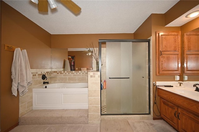 2406 NE 78th Ter, Kansas City, MO 64118 - bathroom featuring ceiling fan, a stall shower, a bath, vanity, and a textured ceiling