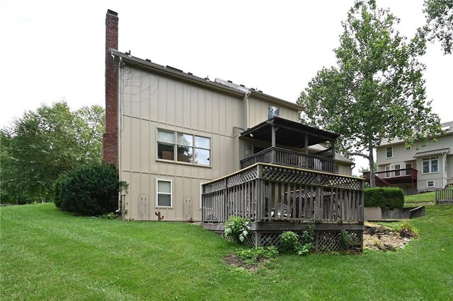 2406 NE 78th Ter, Kansas City, MO 64118 - rear view of house featuring a chimney, a balcony, a yard, board and batten siding, and a deck
