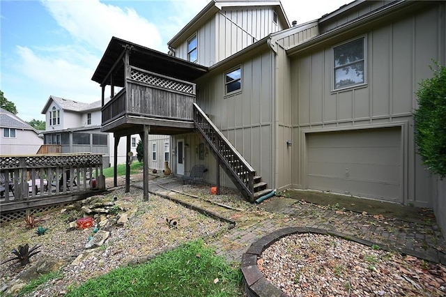 2406 NE 78th Ter, Kansas City, MO 64118 - back of house featuring board and batten siding, a deck, an attached garage, and stairway