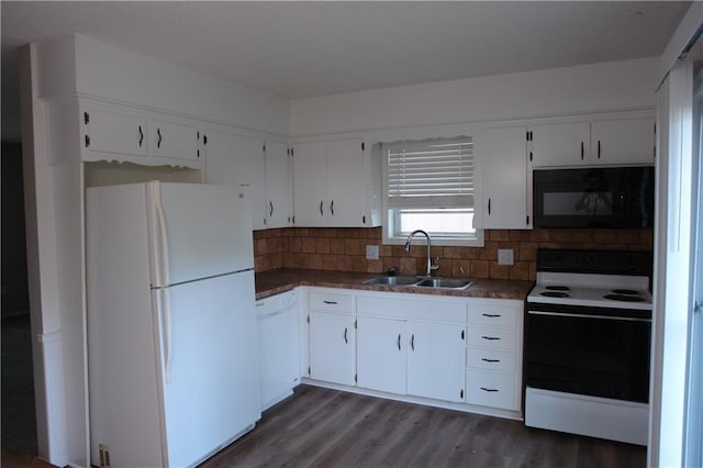 kitchen featuring white appliances, a sink, white cabinetry, and dark countertops