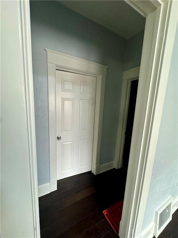 2518 N 12th St, Kansas City, KS 66104 - hallway featuring dark wood-type flooring, baseboards, and visible vents