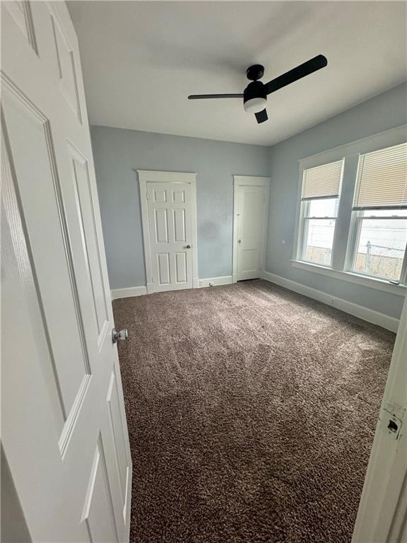 2518 N 12th St, Kansas City, KS 66104 - unfurnished bedroom featuring two closets, a ceiling fan, carpet, and baseboards