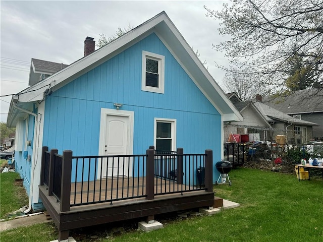 2518 N 12th St, Kansas City, KS 66104 - rear view of house featuring a wooden deck, a chimney, and a lawn