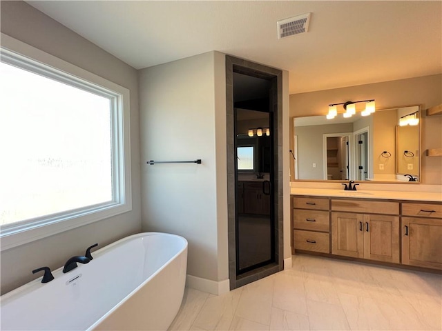 16965 S Mahaffie St, Olathe, KS 66062 - bathroom with plenty of natural light, a freestanding tub, vanity, and baseboards