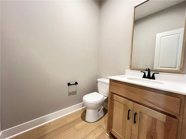 16965 S Mahaffie St, Olathe, KS 66062 - bathroom featuring toilet, vanity, baseboards, and wood finished floors