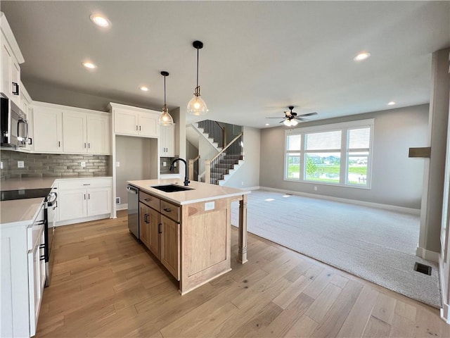 16965 S Mahaffie St, Olathe, KS 66062 - kitchen featuring a sink, appliances with stainless steel finishes, baseboards, ceiling fan, and tasteful backsplash