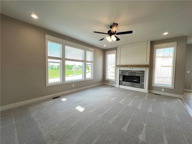 16965 S Mahaffie St, Olathe, KS 66062 - unfurnished living room with baseboards, light carpet, a ceiling fan, a glass covered fireplace, and recessed lighting