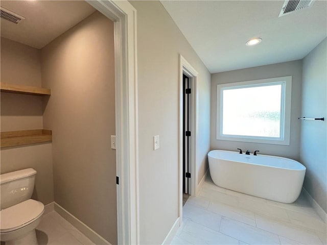 16965 S Mahaffie St, Olathe, KS 66062 - full bathroom with a freestanding tub, toilet, marble finish flooring, baseboards, and recessed lighting