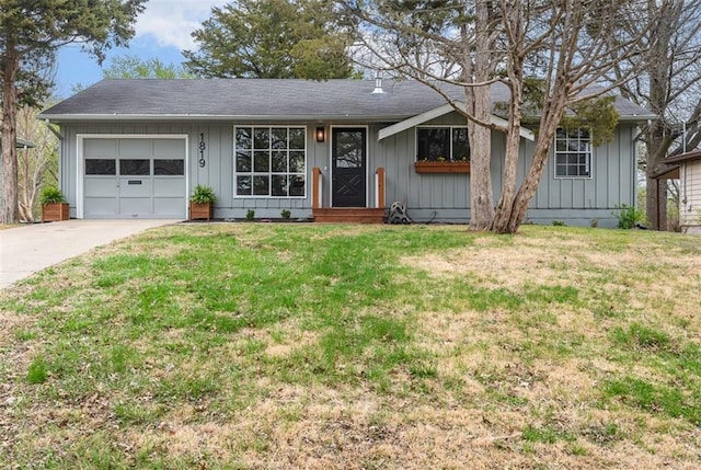 ranch-style house with a front lawn, driveway, an attached garage, and board and batten siding
