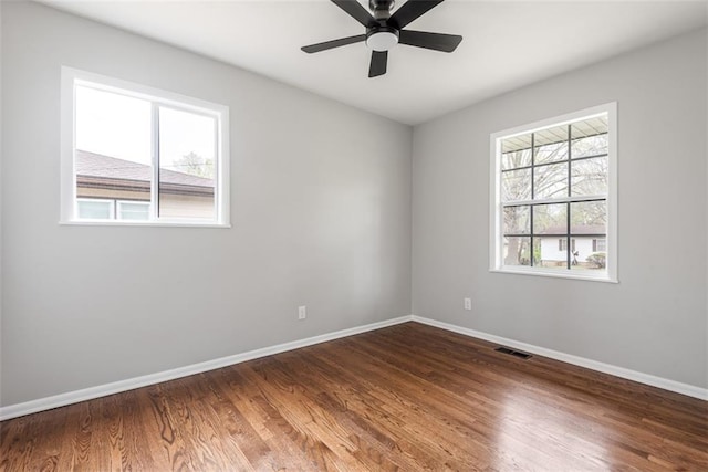 unfurnished room with baseboards, visible vents, and a healthy amount of sunlight
