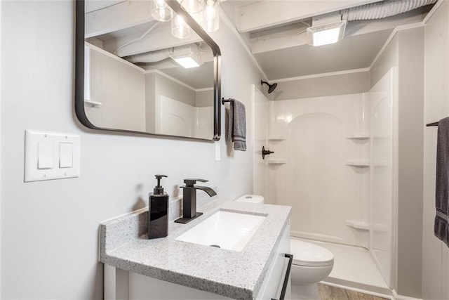 bathroom featuring ornamental molding, toilet, a stall shower, and vanity