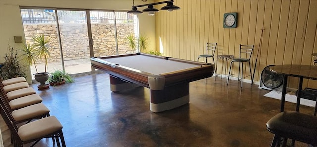 rec room featuring wood walls, pool table, and concrete floors
