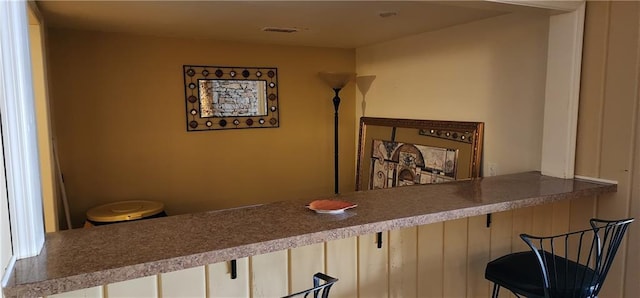 interior space with visible vents and a breakfast bar